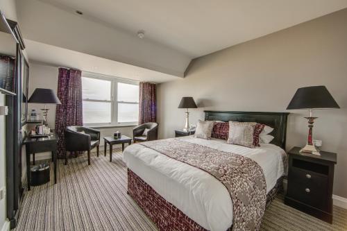 um quarto de hotel com uma cama, uma secretária e uma cadeira em Tynemouth Grand Hotel em Tynemouth