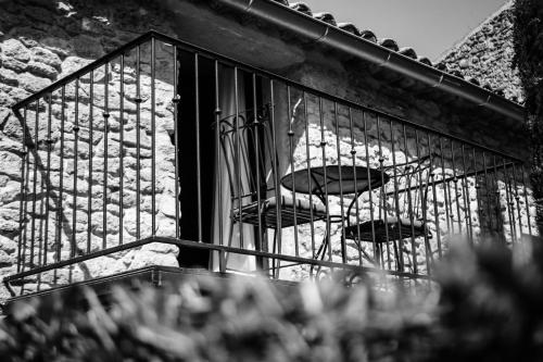 two chairs sitting in a window on a balcony at Le Mas de la Lombarde in Lourmarin