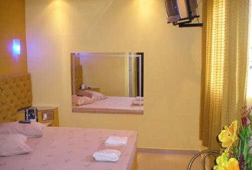 a bedroom with a mirror and a bed with towels at MOTEL RED LOVE in Belo Horizonte