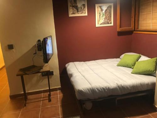 1 dormitorio con 1 cama y mesa con TV en Cal Don Juan, en Torroja