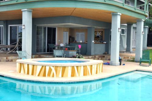 a large swimming pool with a patio and a house at Affordable Luxury on One Acre in Kailua-Kona