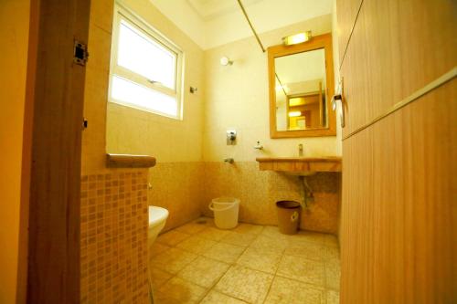 a bathroom with a sink and a toilet and a mirror at Santhoshpuri in Coimbatore