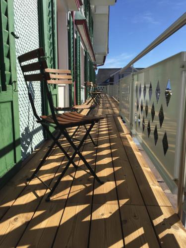 a rocking chair sitting on the side of a balcony at Gasthaus Friedegg in Wildhaus