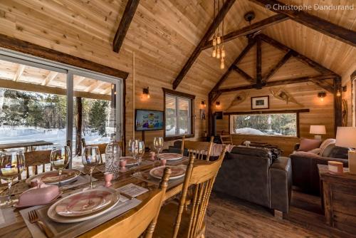 a dining room and living room in a log home at Le Ross in La Malbaie