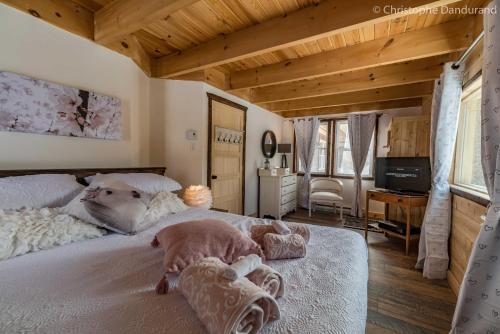 Le Ross - Les Chalets Spa Canada في لا مالباي: غرفة نوم مع سرير مع اثنين من الكلاب يستلقون عليه