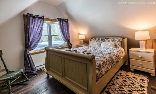 a bedroom with a bed and a window at Le Ross in La Malbaie