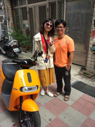 a man and a woman standing next to a motorcycle at mydeer backpacker in Tainan