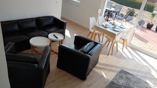 - un salon avec un canapé, une table et des chaises dans l'établissement Ferienwohnung Schreiber, à Hessisch Oldendorf
