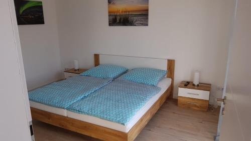 a bedroom with a bed with blue pillows on it at Ferienwohnung Schreiber in Hessisch Oldendorf