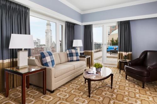 a living room with a couch and a large window at Boston Harbor Hotel in Boston