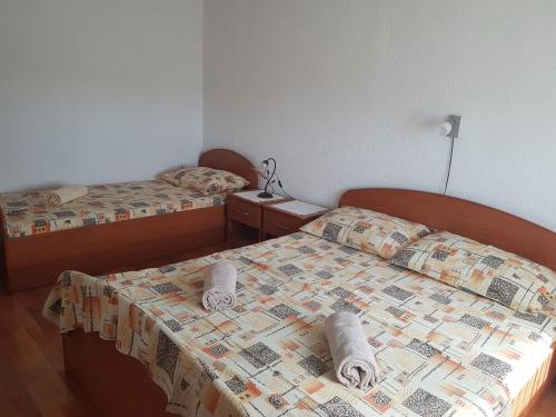 2 Betten in einem Zimmer mit Handtüchern auf dem Bett in der Unterkunft Apartmani Anna in Vir