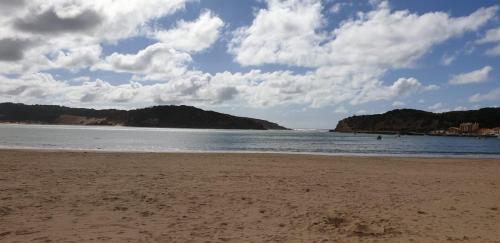 a sandy beach with a view of the ocean at Casinhas da Praia in São Martinho do Porto