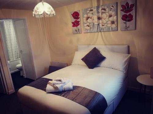 een kleine slaapkamer met een bed met witte lakens en kussens bij Telford Claremont Mews Wellington in Telford