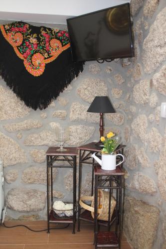 Pokój z dwoma stołami i telewizorem na ścianie w obiekcie Casinha da Raposeira w mieście Soajo