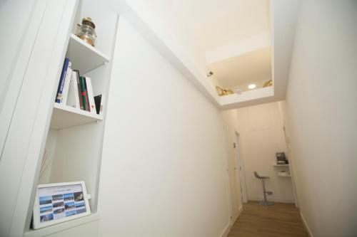 a hallway with white walls and a book shelf at Mediterranean rooms in Castellammare di Stabia