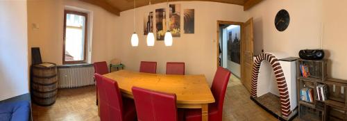 Ferienhaus Am Balduinstor في كوشيم: غرفة طعام مع طاولة خشبية وكراسي حمراء