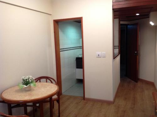 a room with a table and chairs and a kitchen at L'Hirondelle Flat Service in Campinas