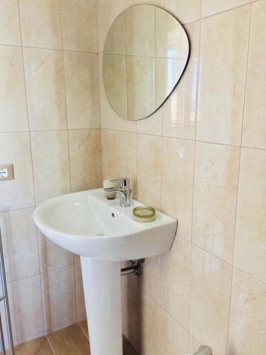 a bathroom with a white sink and a mirror at B&B Pizzomunno e Cristalda Rooms in Vieste