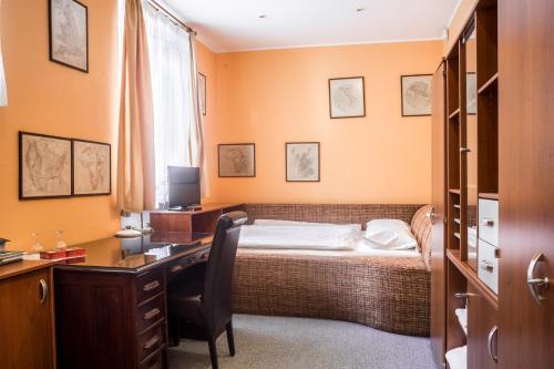 a bedroom with a bed and a desk with a computer at Pension Konopiste in Benešov