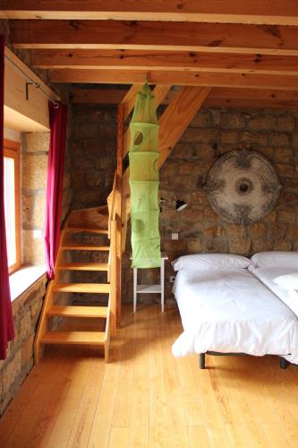 a bedroom with two beds and a wooden wall at La casa de la Petra in Quintanar de la Sierra