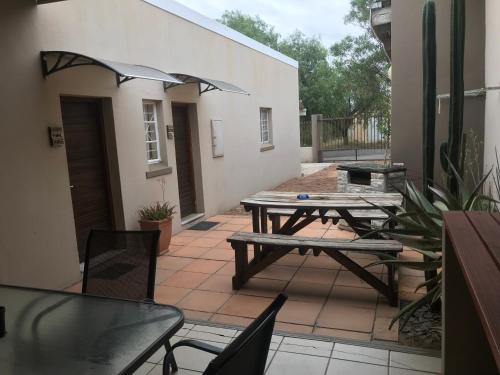 a patio with two picnic tables and chairs on it at Lazy Gecko Accommodation in Cradock