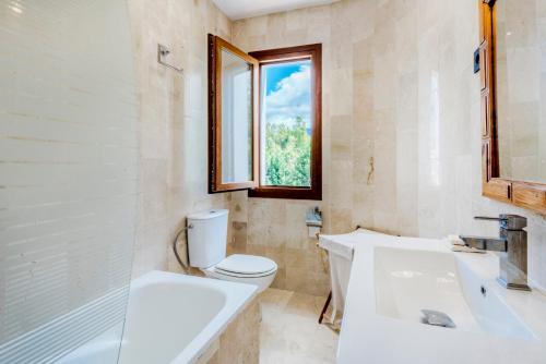 uma casa de banho com 2 lavatórios, um WC e uma janela em Medina Penthouse em Marbella