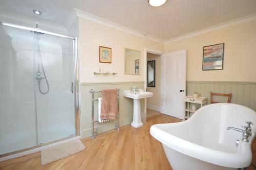 a bathroom with a tub and a shower and a sink at Deerness, 4star gold award 2024, Whitby in Whitby