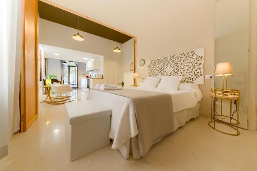 a bedroom with a large bed and a living room at Casa en Plaza de la Merced_Centro Flamenco_Cádiz in Cádiz
