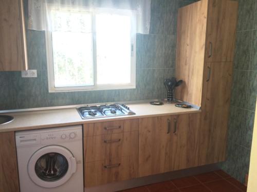 a kitchen with a washing machine and a window at Rural El Puerto Mayordomo in Ardales