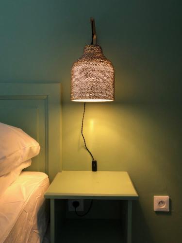 a lamp on a table next to a bed at Hotel Pelican in Schœlcher