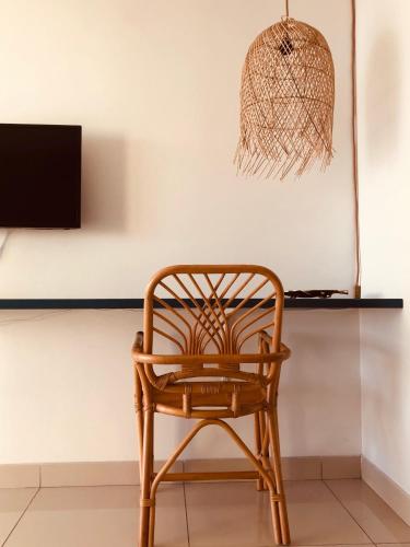 a rattan chair in a room with a wall at Hotel Pelican in Schœlcher