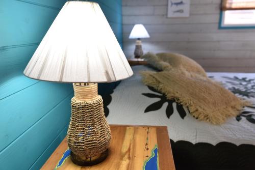 a lamp sitting on a table next to a bed at The BlueBamboo in Le Moule