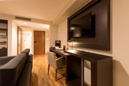 a living room with a couch and a television on a wall at Caseros 248 Hotel in Cordoba