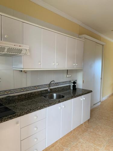 a kitchen with white cabinets and a sink at Dream Bahia in Santa Cruz de Tenerife