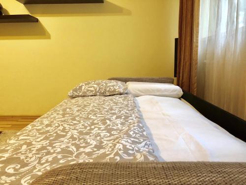 a bed sitting in a room with a pillow on it at Cozy and Clean Apartment, near National Arena in Bucharest