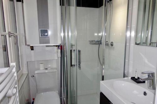 a bathroom with a shower and a toilet and a sink at Appartement Trouville s/mer Plage in Trouville-sur-Mer
