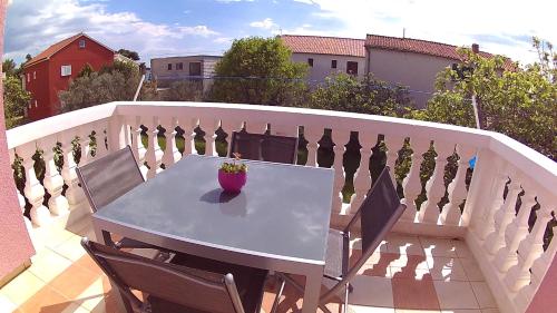 a table and chairs on a balcony with a fence at House Srima-Vodice Dalmatia in Srima