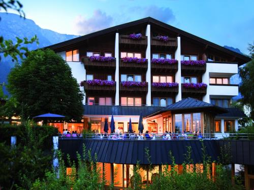 un hôtel avec des tables et des chaises devant lui dans l'établissement Landgasthof Bogner, à Absam