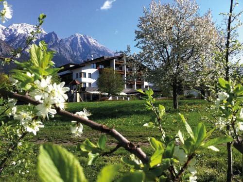 a house in a field with mountains in the background at Landgasthof Bogner by SMK Event und Gastro in Absam