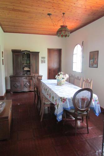 a dining room with a table and some chairs and a table and chairsktop at Sitio Prainha in Guararema