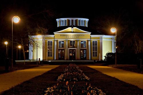 a building at night with lights in front of it at Dr. Adler Spa & Kurhotel in Františkovy Lázně
