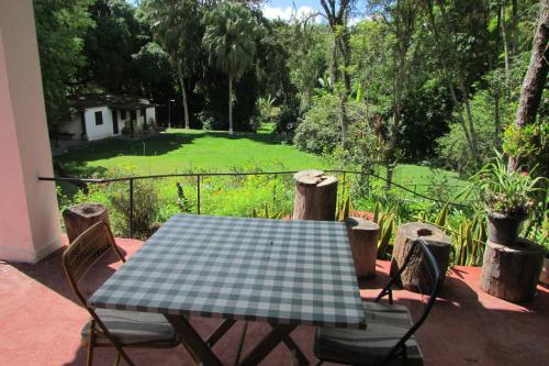 a table and chairs on a patio with a green yard at Sitio Prainha in Guararema