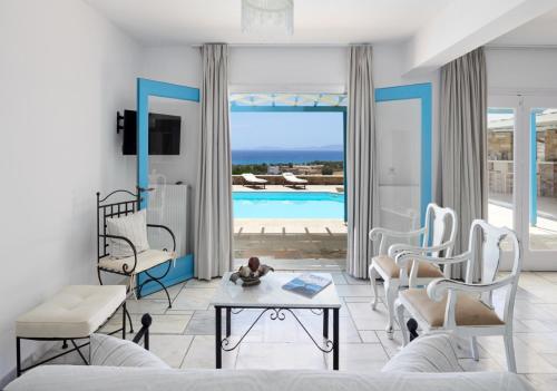 a living room with a couch and a table and a pool at Marble Villas in Tinos Town