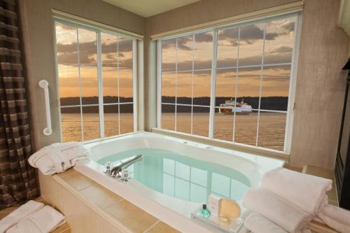 a bathroom with a tub with a view of the ocean at Silver Cloud Hotel - Mukilteo Waterfront in Mukilteo