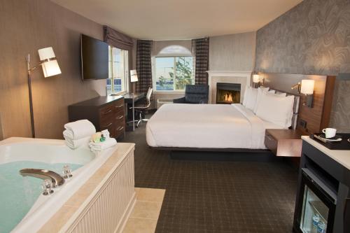 ムキルテオにあるSilver Cloud Hotel - Mukilteo Waterfrontのベッドとバスタブ付きのホテルルームです。
