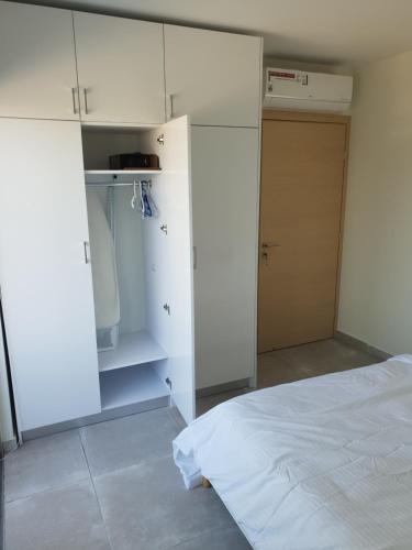 a white bedroom with a bed and a closet at Egkomi Luxury Spacious apartment in Yukarı Lakatamya