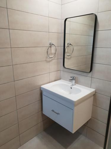 a bathroom with a sink and a mirror at Egkomi Luxury Spacious apartment in Yukarı Lakatamya