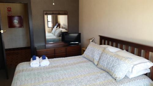 a bedroom with a bed with two shoes on it at Foveaux Hotel in Bluff