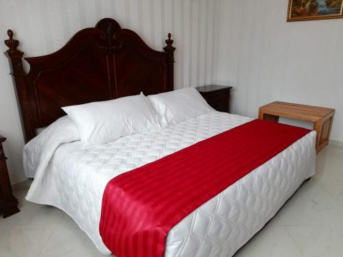 a bed with a red and white blanket on it at Hacienda Maxdá in Santiaguito Maxdá