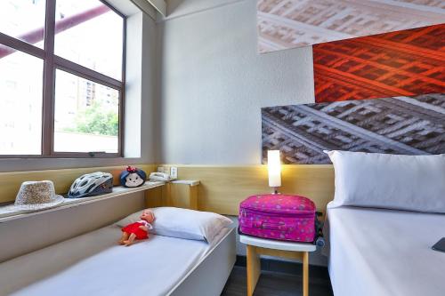 Un pat sau paturi într-o cameră la Ibis Maringa
